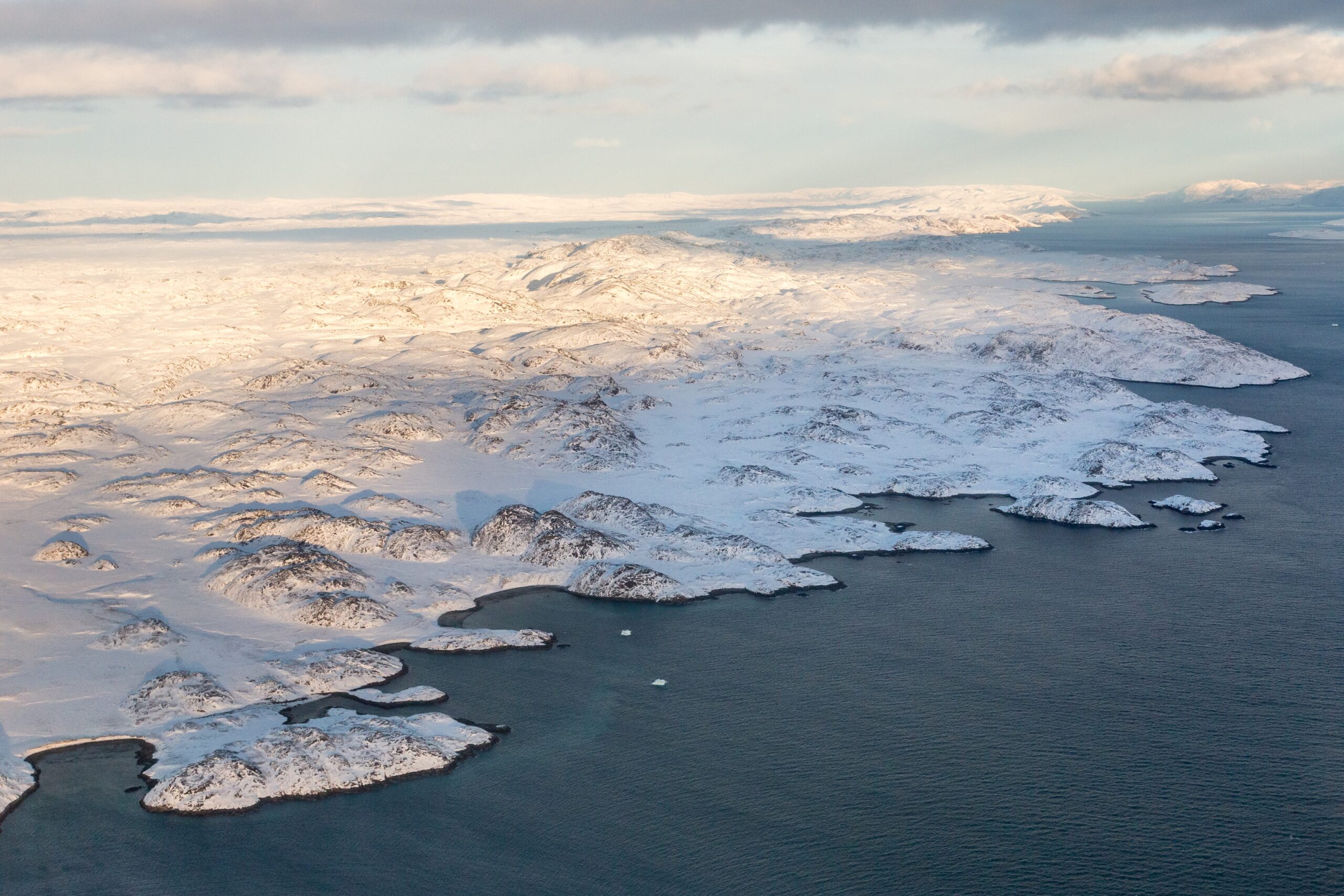 Greenlandic,Ice,Cap,With,Frozen,Mountains,And,Fjord,Aerial,View,